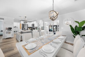 Una cocina moderna con armarios blancos, un refrigerador de acero inoxidable y una isla central.