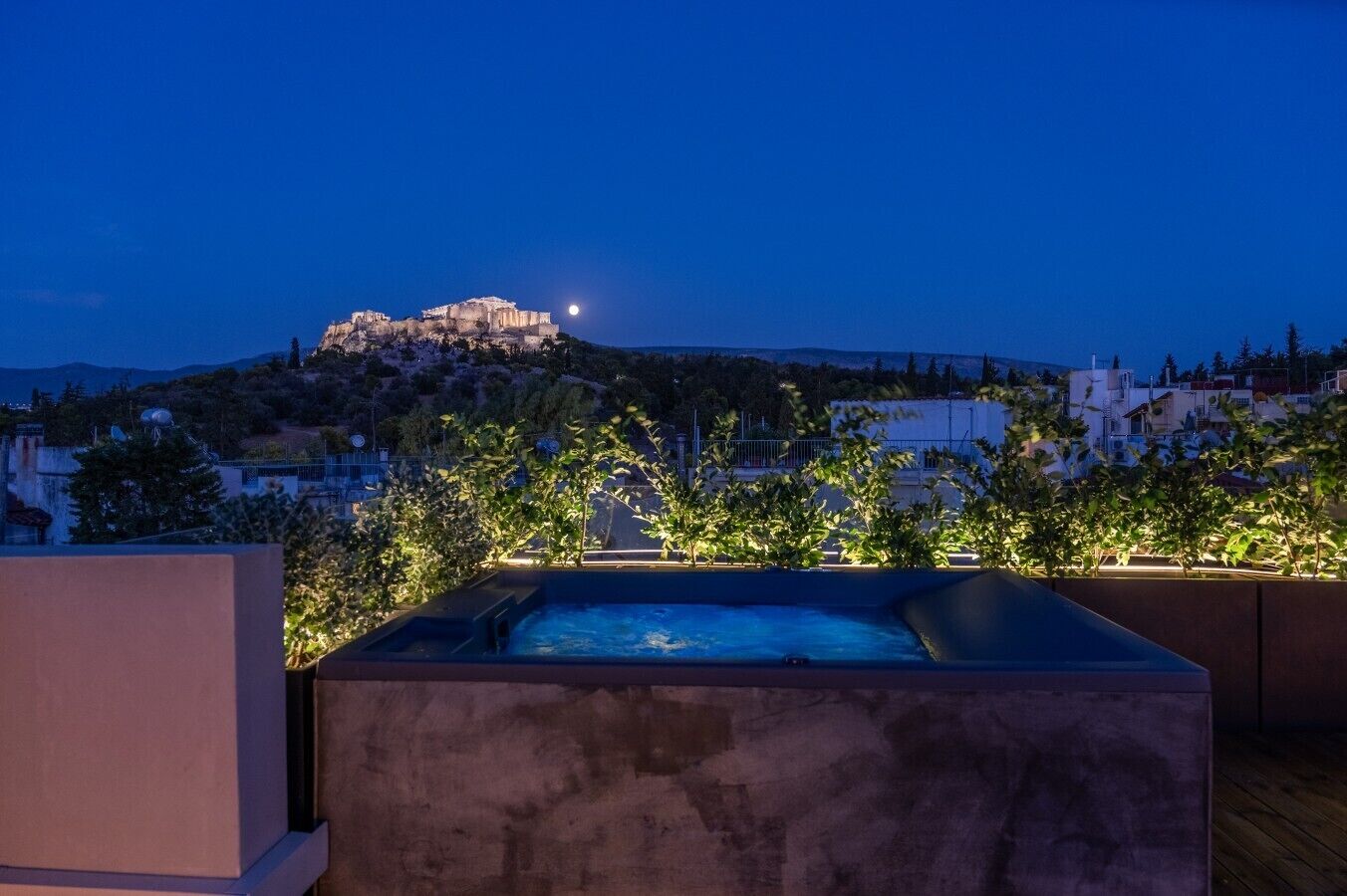 A rooftop pool with a view of a historic hilltop structure and surrounding buildings.