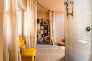 A room with a yellow sofa, a wall of framed pictures, and a door with a decorative handle. - Architect’s Masterpiece Villa with Private Rooftop (Athina)