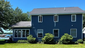 Ein zweistöckiges blaues Haus mit gepflegtem Rasen.