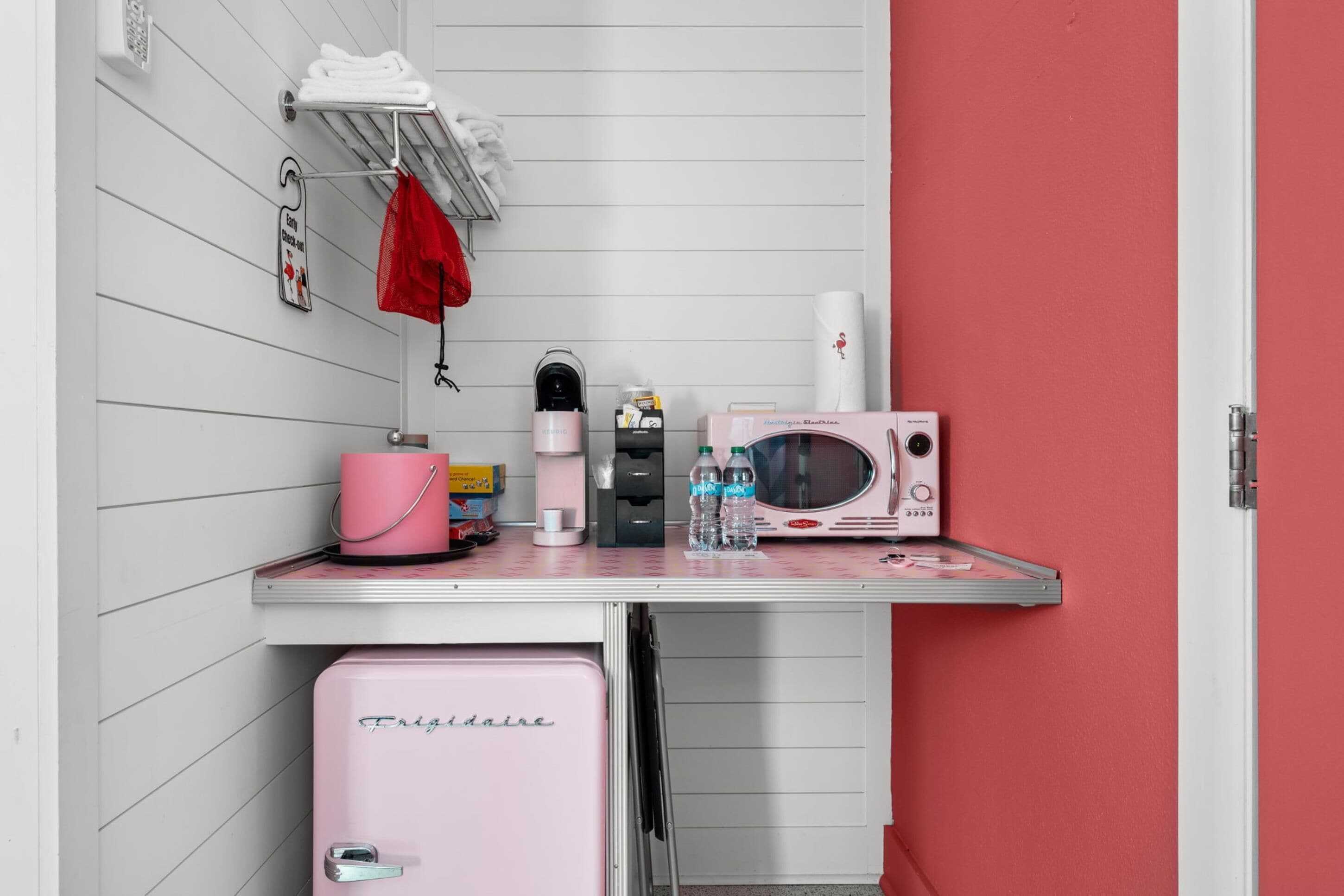 A compact kitchenette with a microwave, a small fridge, a coffee maker, and a water dispenser.