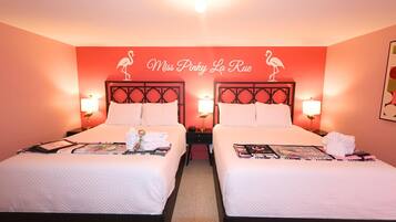Une chambre d’hôtel avec deux lits, chacun doté d’une tête de lit, de lampes de chevet et d’un élément décoratif mural sur lequel on peut lire : « Miss Pinky La Rue ».