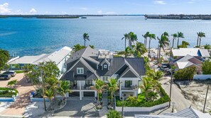 Une propriété située en bord de mer, comprenant une grande maison, une piscine et des palmiers.