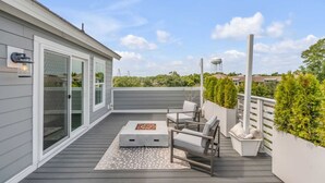 Eine überdachte Terrasse im Freien mit Sitzgelegenheit, einem Wasserspiel und Blick auf die Umgebung.