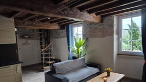 Un salon chaleureux avec un canapé, une table en bois et un escalier.