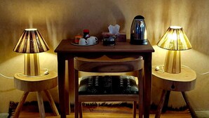 Een kamer met een houten tafel, twee lampen, een schilderij en een vloerbedekking.