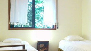 A room with two single beds, a wooden chair, a small table, and a window with curtains. - A Peaceful Riverside Escape Just Minutes from Porto (São Cosme)