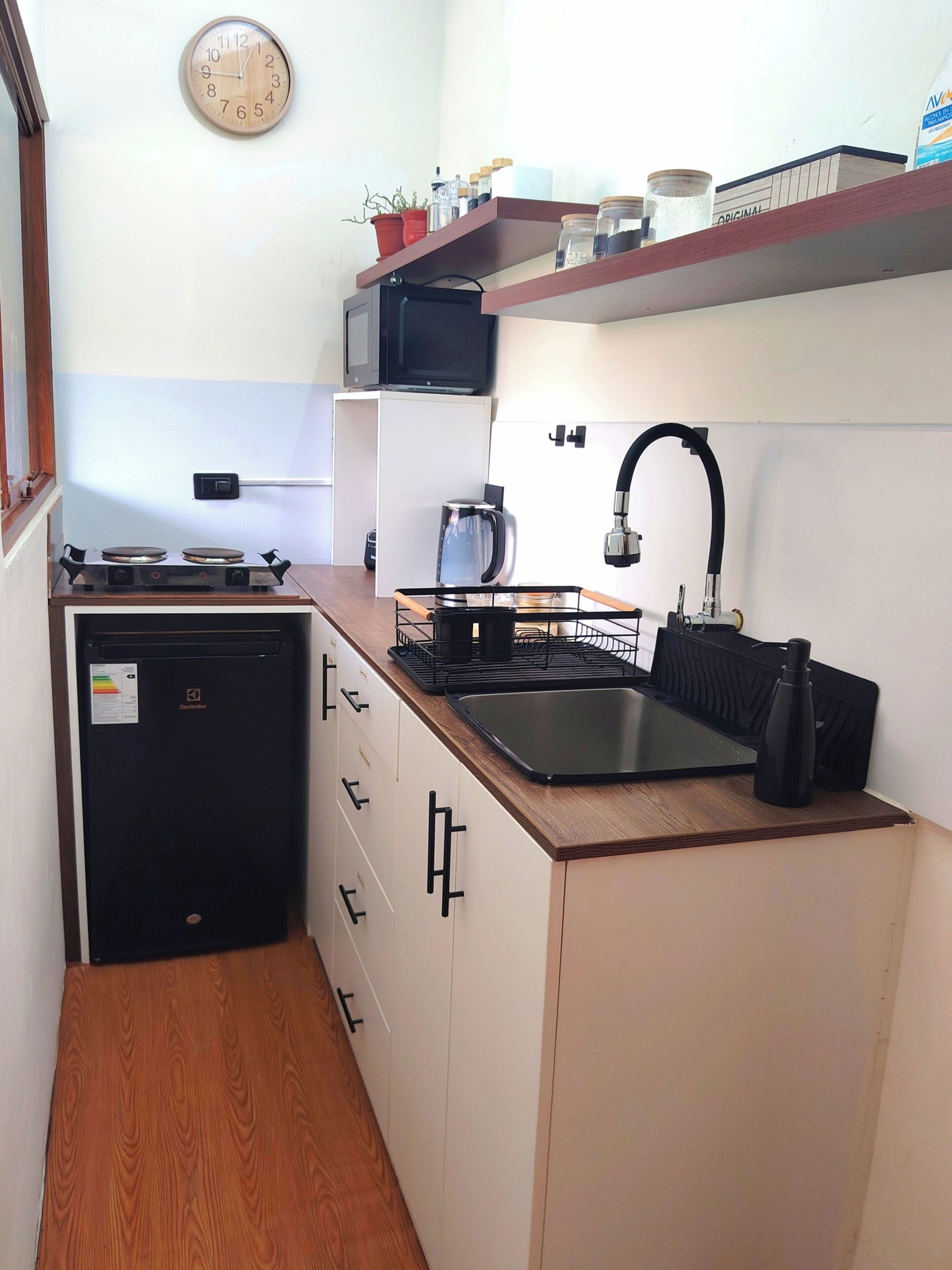 A compact kitchen with a stove, sink, and storage cabinets.
