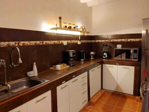 Une cuisine équipée d’un évier, d’une cuisinière, d’un four à micro-ondes et de placards.
