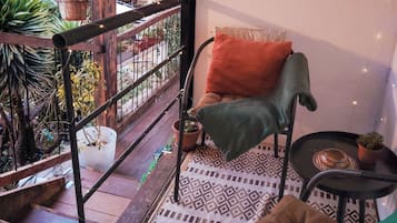 Un ambiente accogliente con una poltrona, un tavolino e un cartello di benvenuto.