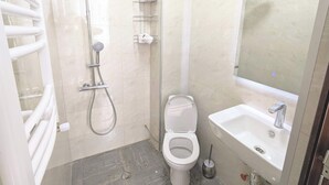 Een moderne badkamer met douche, toilet en wastafel.