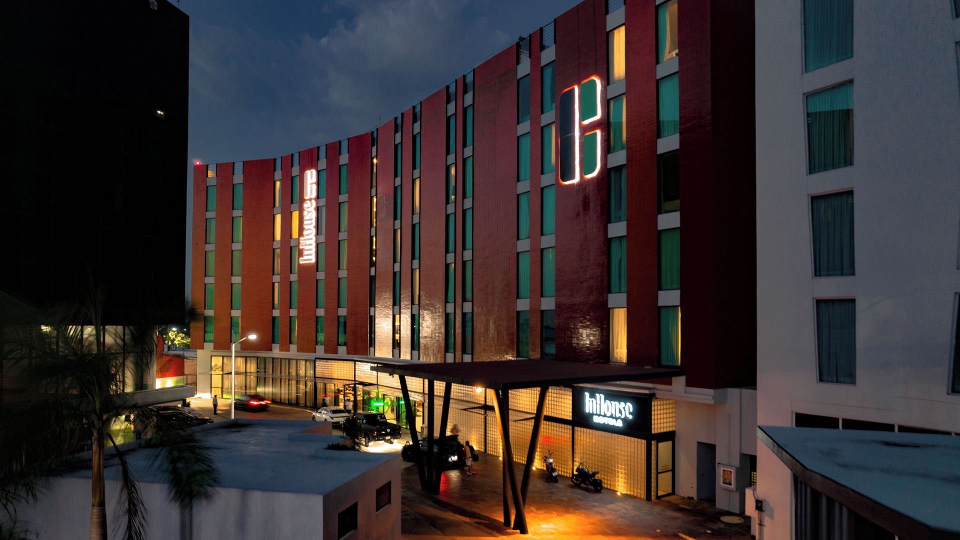 Un hotel modern amb una façana corba, nombroses finestres i una entrada destacada amb una marquesina.