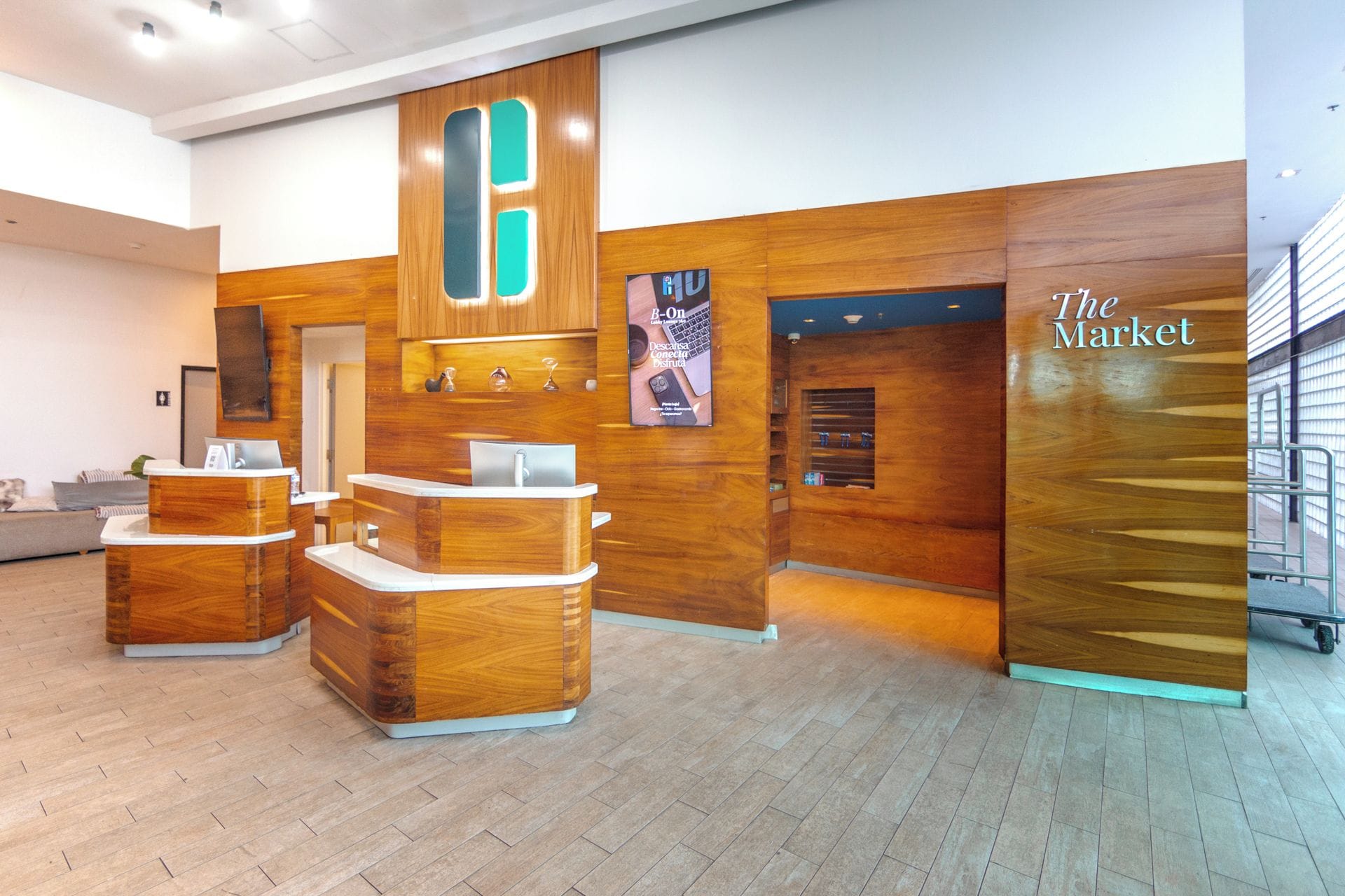 Un área de recepción con mostradores de madera, un letrero en la pared y una puerta con la leyenda 'The Market'.