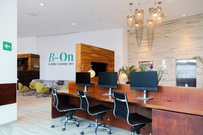 A lobby lounge with a reception desk, three monitors, and a modern chandelier. - InHouse Ciudad del Carmen  (Ciudad del Carmen)