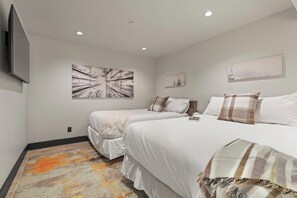 Ein Hotelzimmer mit zwei Betten, einem Fernseher und Bildern an den Wänden.