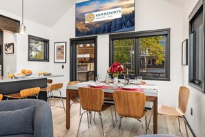 Ein moderner Essbereich mit großem Fenster, einem Tisch für vier Personen und einem Schild für KBM Resorts.