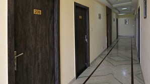 A hallway with doors numbered 206 and 207, marble flooring, and recessed ceiling lights. - Townhouse Reti Bus Terminal Udaipur (Udaipur)