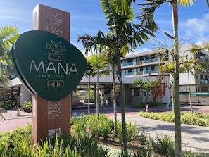 A sign for 'MANA Beach Experience' with a modern building in the background. - Mana Beach Experience (Ipojuca)