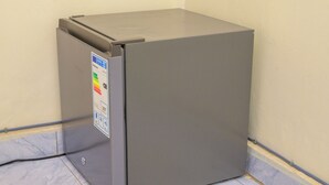 A compact, gray refrigerator with a sticker indicating energy efficiency.