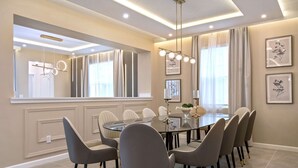 A dining area with a round table, eight chairs, and a chandelier. - Dream 9BR Home - Game Room - Hot Tub - Sleeps 22! (Kissimmee)