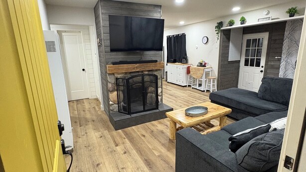 Una sala de estar moderna con chimenea, un sofá, una mesa de centro y un televisor montado en la pared.