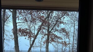 A view from inside a building looking out to a wooden deck with snow on the ground and trees in the background. - Where wilderness meets luxury on Lake Winnie/Chippawa National Forest (Bena)