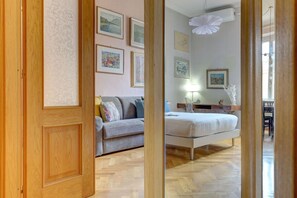 A bedroom with a bed, a sofa, and a dining area with a table and chairs. - Vatican | The House of Painting | Home and More (ROMA)