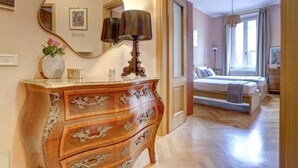 Ein Schlafzimmer mit einem hölzernen Schminktisch, einem Bett und einem großen Spiegel.