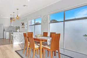 A modern kitchen with white cabinets, a marble countertop, and pendant lighting. - The Beach Break Laid back Comfort by Aldinga Beach (Aldinga Beach)
