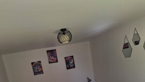 A bedroom with a bed, two bedside tables, a wall-mounted lamp, and three wall art pieces. - Maison du pecher 10 minutes from Beauval zoo (Couffy)
