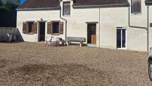 A two-story stone building with a gravel driveway, wooden shutters, and a bench outside. - Maison du pecher 10 minutes from Beauval zoo (Couffy)