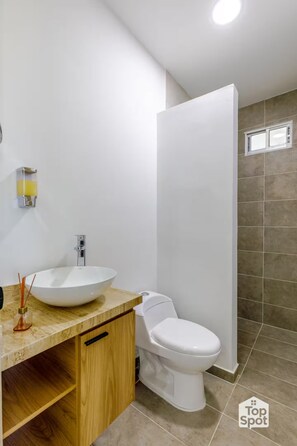 Ein modernes Badezimmer mit Waschbecken, Holzschrank und Toilette.