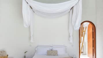 A spacious bedroom with a large bed, a hanging chair, and a wooden ceiling.