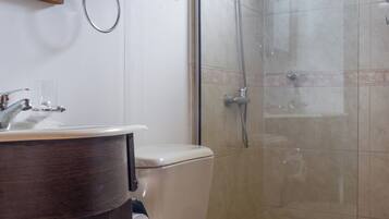 A bathroom with a toilet, sink, and shower.