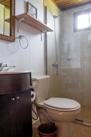 A bathroom with a toilet, sink, and shower.