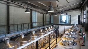 A kitchen with stainless steel equipment, hanging lights, and a window with a view. - Viña Edén (El Edén)