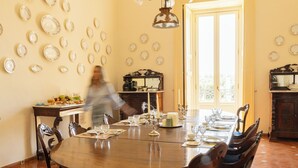 A dining room with a large wooden table set for a meal, surrounded by chairs.