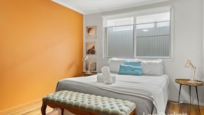 A bedroom with a bed, a bench, a nightstand, and a window. - Sea Whisper - Lennox Head Village (Lennox Head)