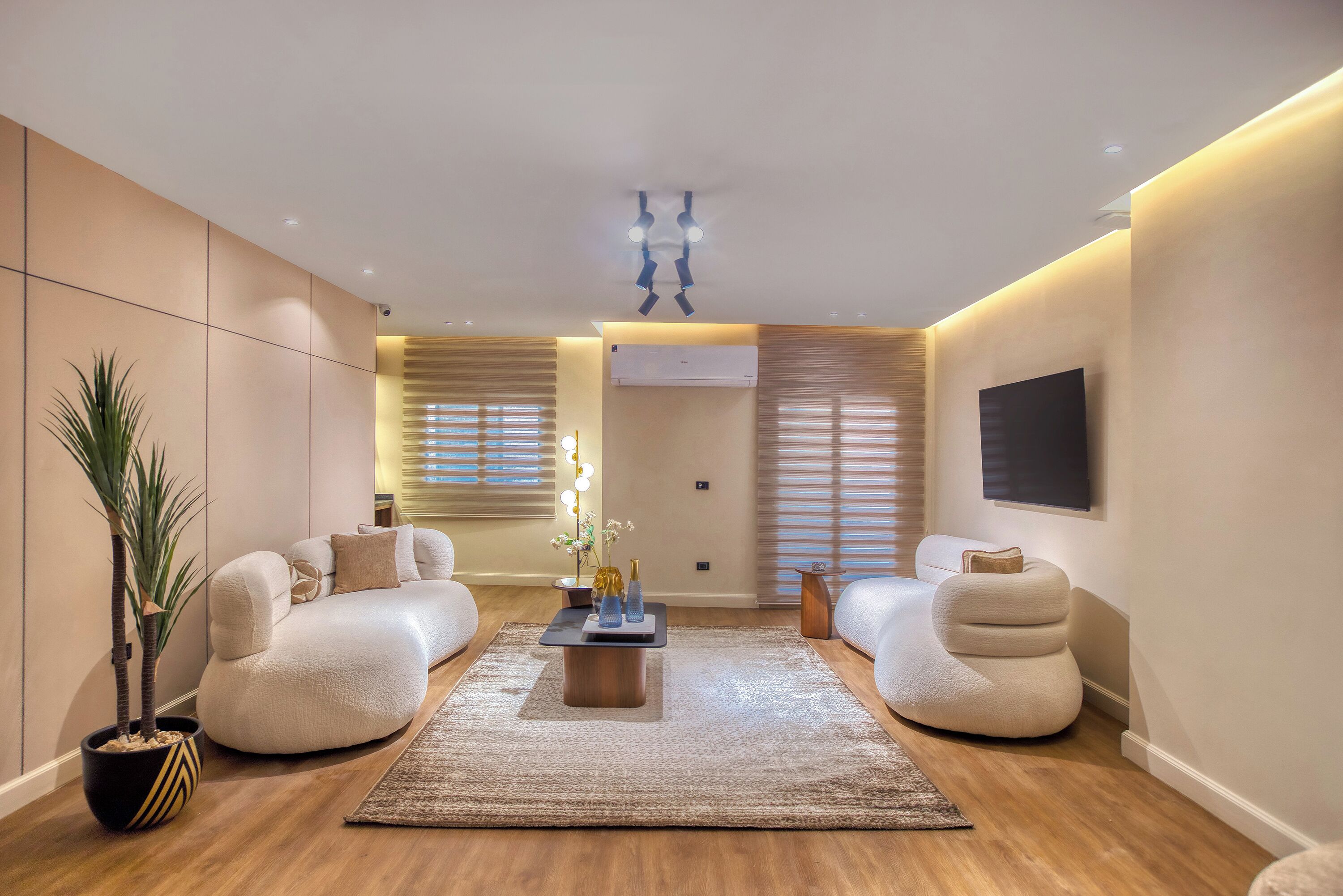 A modern living room with a sofa, a coffee table, and a TV.