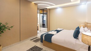 Een moderne hotelkamer met een groot bed, een nachtkastje, een lamp en een spiegel.