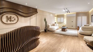 Een moderne woonkamer met een opvallend golvend muurontwerp, een ruime bank en een salontafel.