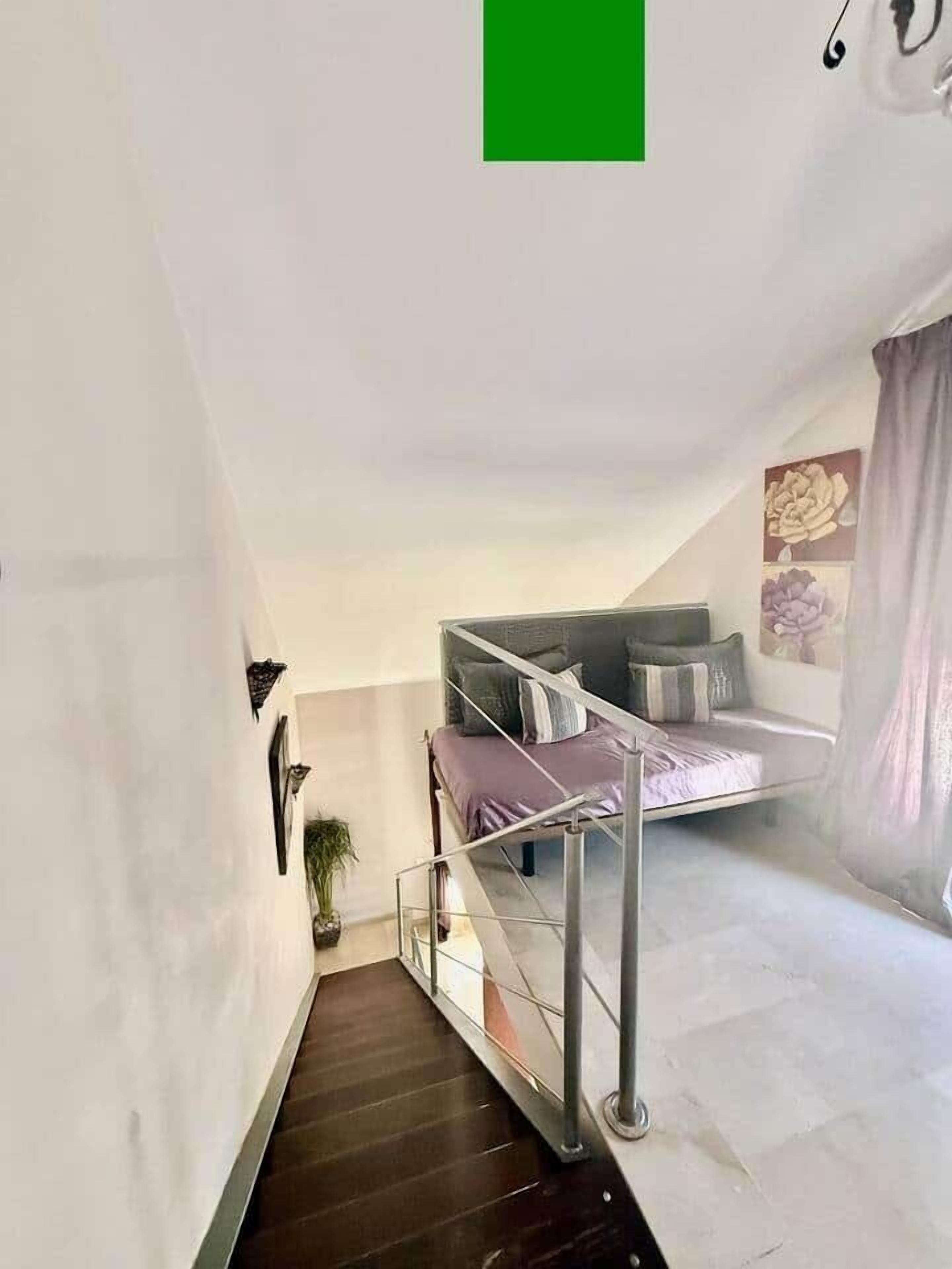A modern interior with a staircase leading to a loft bedroom.