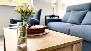 Ein Holztisch mit einer Blumenvase und einer Schale Schokolade.