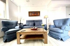 A living room with a sofa set, a coffee table, and a painting on the wall. - Tendillas Penthouse: Córdoba Center (Córdoba)