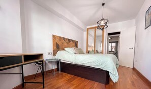 Une chambre à coucher avec un lit, une table de chevet et un miroir.