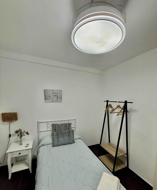 A bedroom with a bed, bedside table, lamp, and a wall-mounted picture. - Casa Paula in Córdoba (Córdoba)
