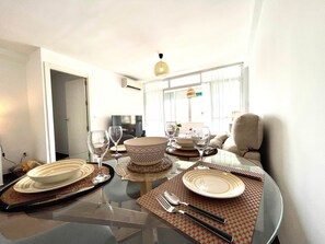 A dining area with a round table set for four, including plates, glasses, cutlery, and a woven placemat. - Casa Paula in Córdoba (Córdoba)