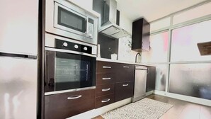 Uma cozinha com forno embutido, micro-ondas e máquina de lavar louça.