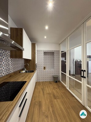 A modern kitchen with a wooden countertop, a built-in oven, and a patterned backsplash. - Peace of Mind: Córdoba (Córdoba)