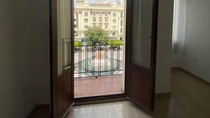 Ein offener Balkon mit Blick auf ein großes Gebäude und einen runden Platz.